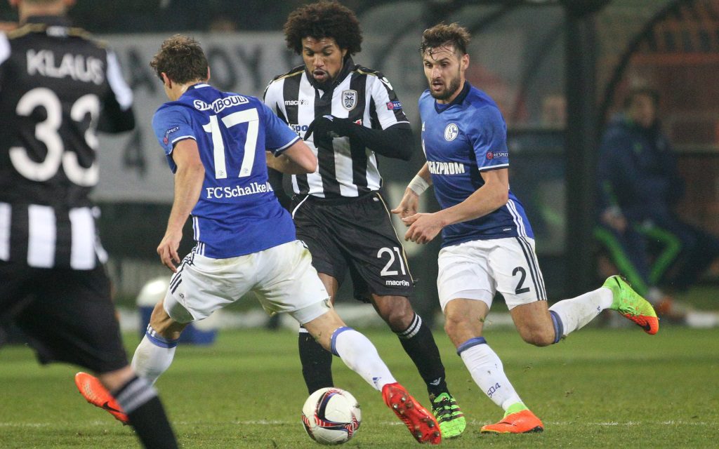 Benjamin Stambouli (li.) und Daniel Caligiuri (re.) attackieren Diego Biseswar (Mi.) in der Zwischenrunde der Europa League zwischen PAOK und dem FC Schalke