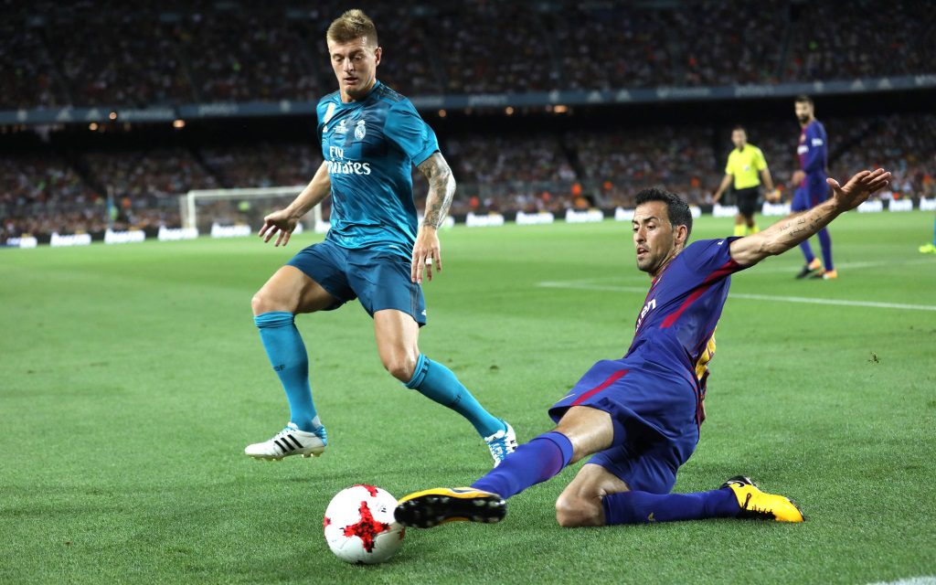 Sergio Busquets klärt mit der Grätsche vor Toni Kroos im Supercopa-Hinspiel FC Barcelona - Real Madrid in der Saison 2017/18.