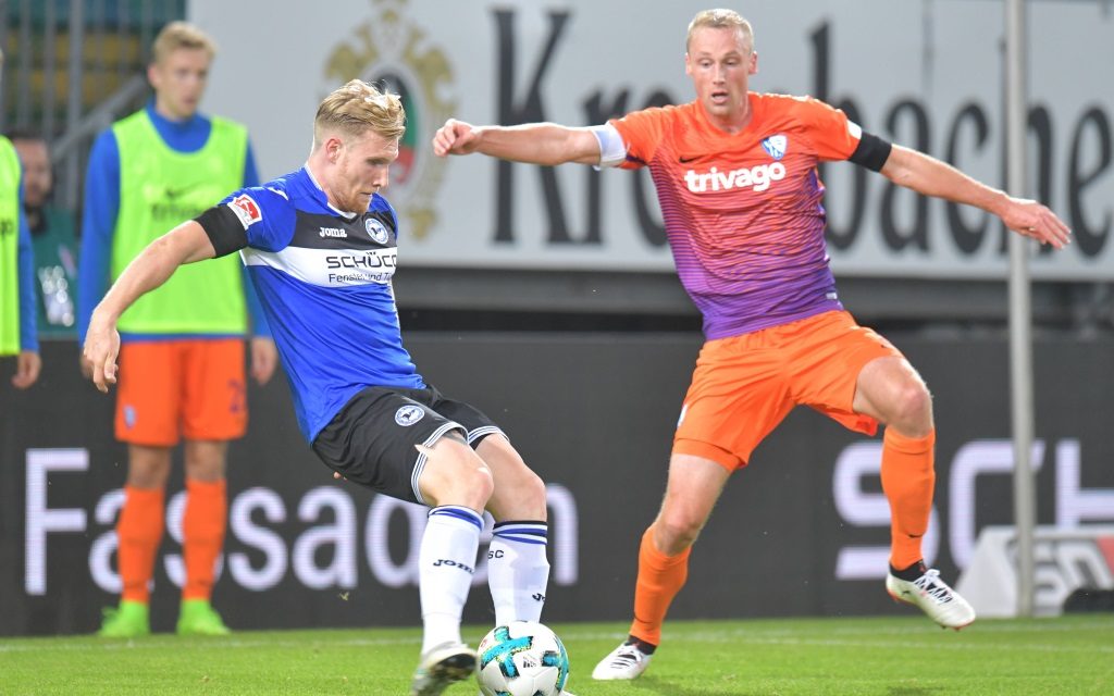 Andreas Voglsammer beim Schussversucht vor Felix Bastians im Spiel Arminia Bielefeld - VfL Bochum.